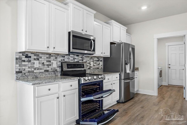 10826 Blacktail Loop, Pensacola, FL 32526 - kitchen featuring appliances with stainless steel finishes, washer / dryer, white cabinetry, and tasteful backsplash