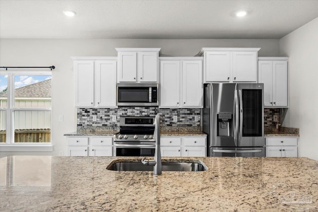 10826 Blacktail Loop, Pensacola, FL 32526 - kitchen featuring stainless steel appliances, white cabinets, decorative backsplash, light stone counters, and recessed lighting