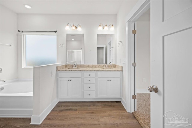 10826 Blacktail Loop, Pensacola, FL 32526 - bathroom with wood finished floors, double vanity, a bath, and baseboards