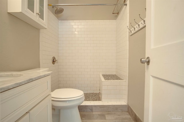 bathroom featuring vanity, toilet, and tiled shower