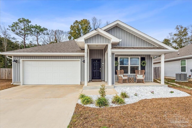 view of front of property with cooling unit, a porch, and a garage