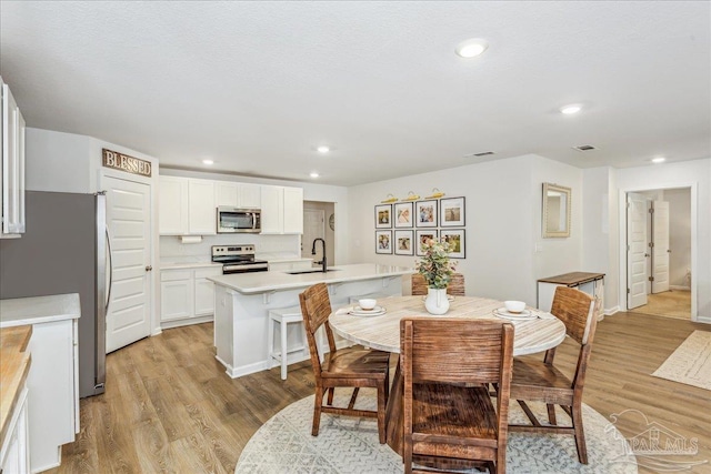 dining area featuring sink and light hardwood / wood-style floors