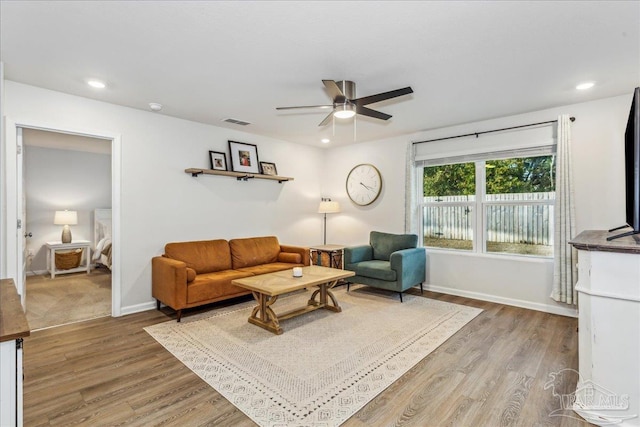 living room with wood-type flooring and ceiling fan