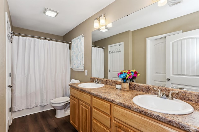 bathroom with a sink, visible vents, toilet, and wood finished floors