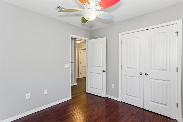 unfurnished bedroom featuring visible vents, baseboards, a closet, and wood finished floors
