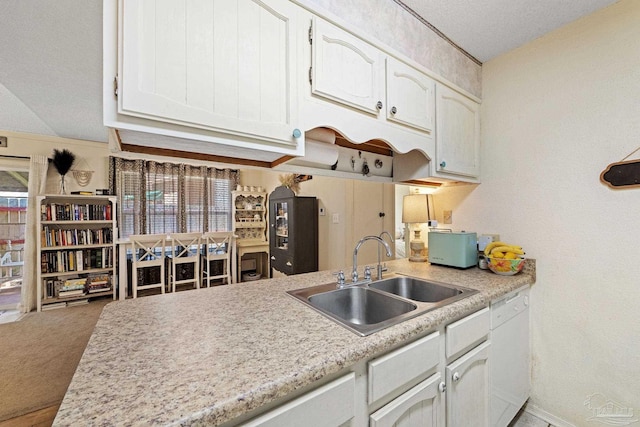 kitchen with a sink, white cabinetry, white dishwasher, light countertops, and light colored carpet