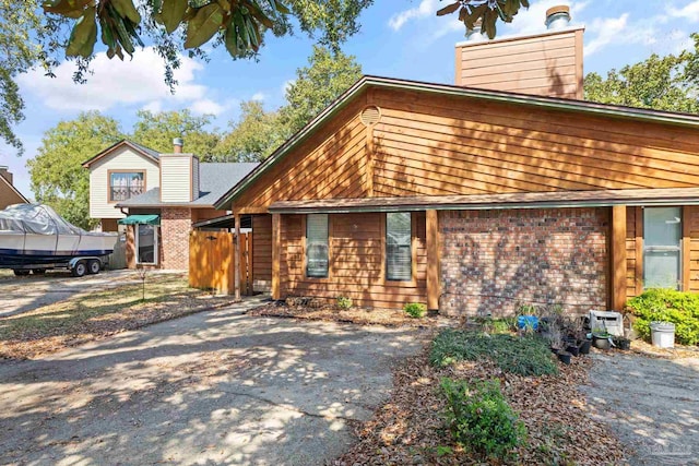 view of front of home featuring brick siding and a chimney