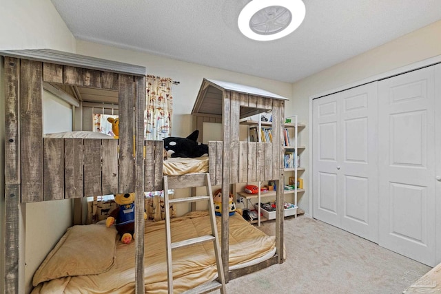 bedroom with a closet, a textured ceiling, and carpet floors