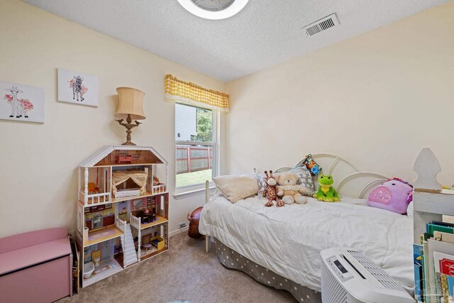 bedroom with visible vents, carpet flooring, and a textured ceiling