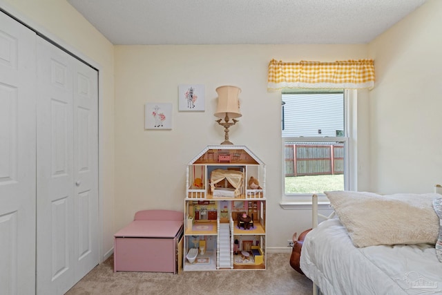 carpeted bedroom featuring a closet, baseboards, and a textured ceiling