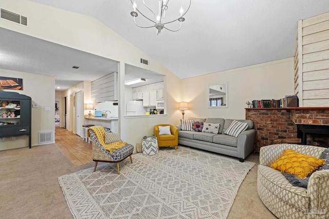 living area with visible vents, a fireplace, and vaulted ceiling