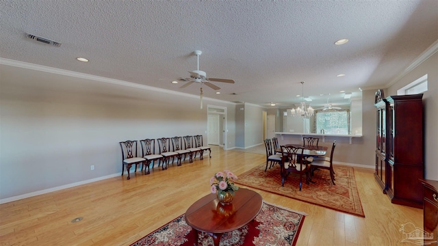 interior space featuring crown molding, ceiling fan with notable chandelier, a textured ceiling, and light wood-type flooring