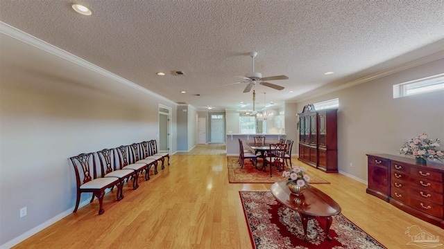 living room with crown molding, plenty of natural light, and light wood-type flooring