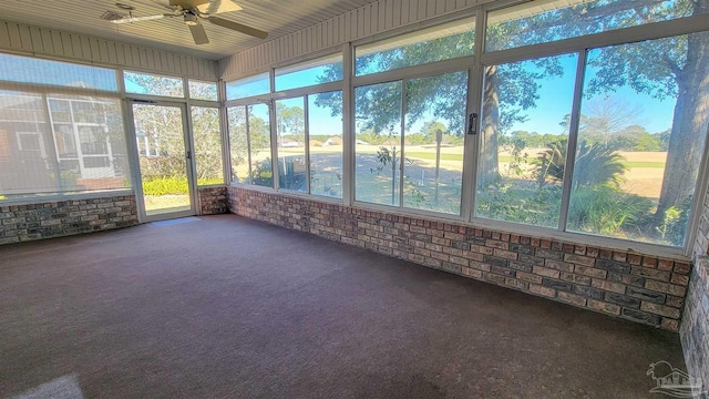 unfurnished sunroom featuring ceiling fan and plenty of natural light