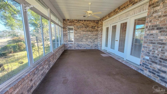 unfurnished sunroom featuring ceiling fan