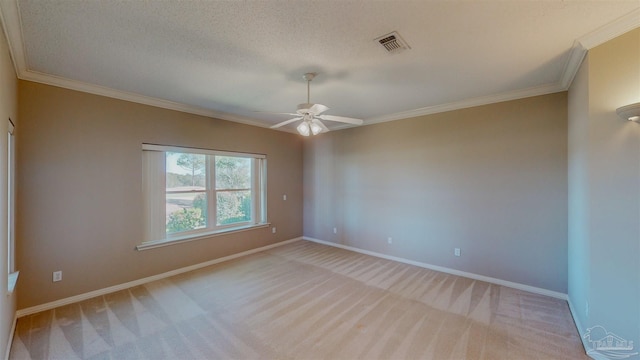 carpeted spare room featuring crown molding, a textured ceiling, and ceiling fan