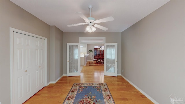 hall with light hardwood / wood-style flooring and french doors