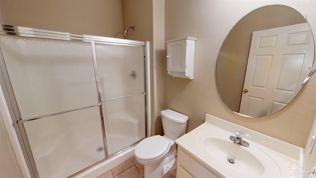 bathroom with vanity, toilet, a shower with shower door, and tile patterned flooring