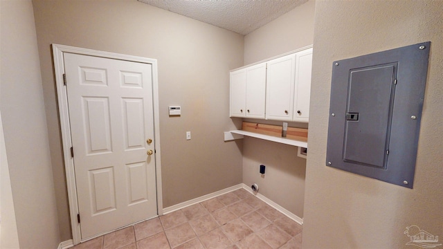 laundry room with cabinets, hookup for an electric dryer, electric panel, and a textured ceiling