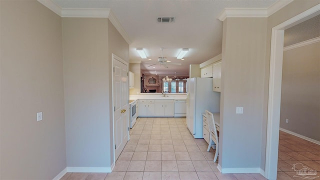 kitchen with crown molding, white appliances, white cabinets, and light tile patterned flooring