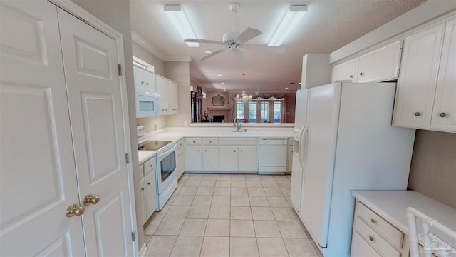 kitchen with sink, white appliances, light tile patterned floors, ceiling fan, and white cabinets