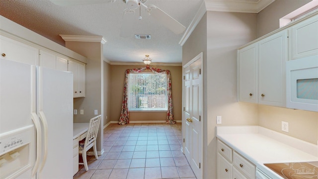 kitchen featuring a textured ceiling, light tile patterned floors, ornamental molding, white appliances, and white cabinets