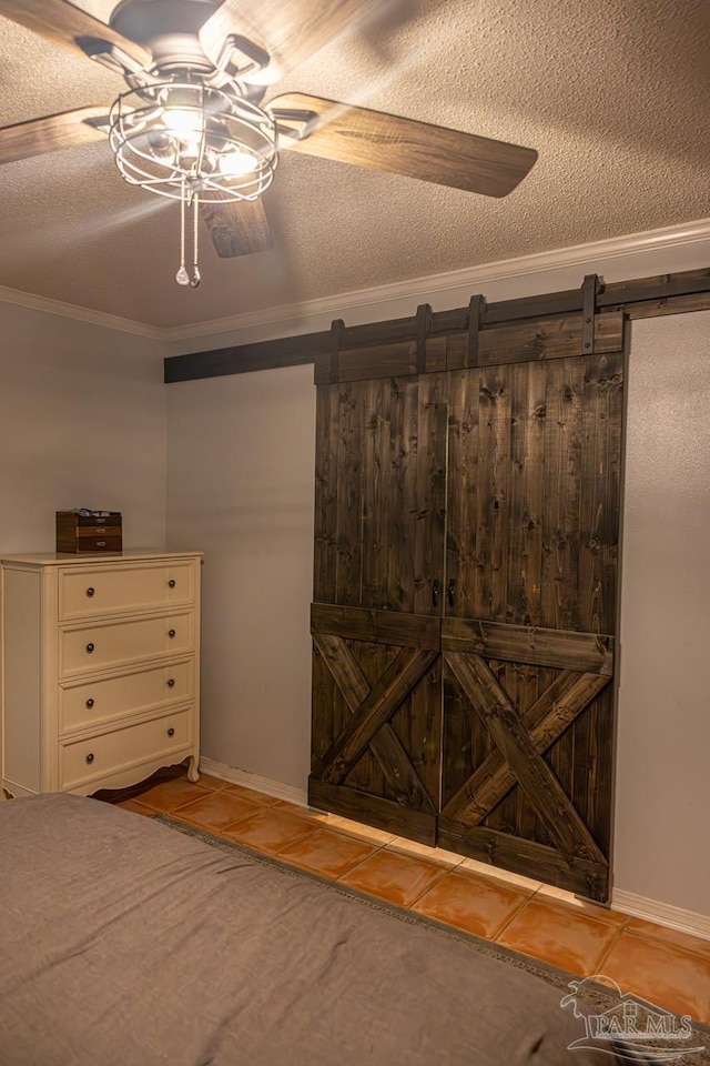 10129 Huntsman Path, Pensacola, FL 32514 - unfurnished bedroom with crown molding, a barn door, and tile patterned flooring