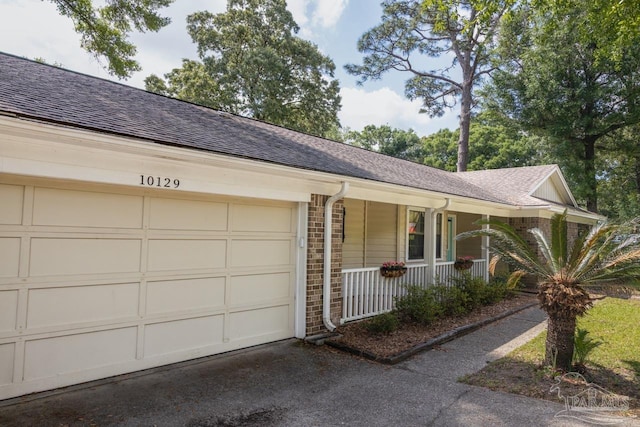 10129 Huntsman Path, Pensacola, FL 32514 - ranch-style house with a shingled roof, an attached garage, brick siding, covered porch, and driveway