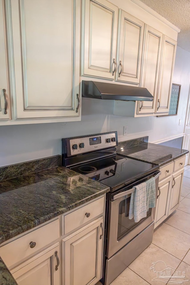 10129 Huntsman Path, Pensacola, FL 32514 - kitchen featuring dark stone countertops, light tile patterned floors, under cabinet range hood, and stainless steel range with electric cooktop