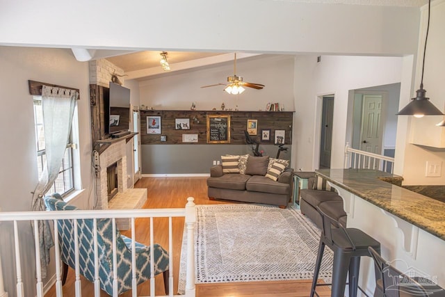 10129 Huntsman Path, Pensacola, FL 32514 - living room with a fireplace, a ceiling fan, beam ceiling, and light wood-style floors