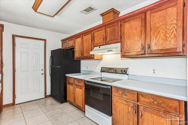 5471 Shamrock St, Milton, FL 32570 - kitchen with under cabinet range hood, white electric range, freestanding refrigerator, brown cabinetry, and light countertops