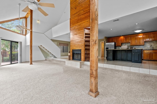 1567 Whisper Bay Blvd, Gulf Breeze, FL 32563 - unfurnished living room featuring a ceiling fan, light colored carpet, a sink, high vaulted ceiling, and a glass covered fireplace