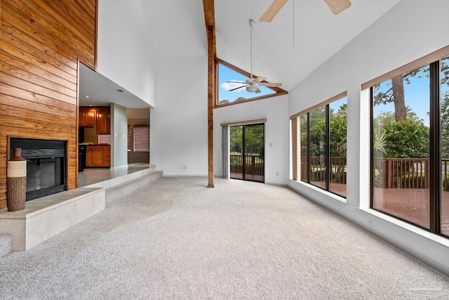 1567 Whisper Bay Blvd, Gulf Breeze, FL 32563 - unfurnished living room with light carpet, high vaulted ceiling, a fireplace, ceiling fan, and wood walls