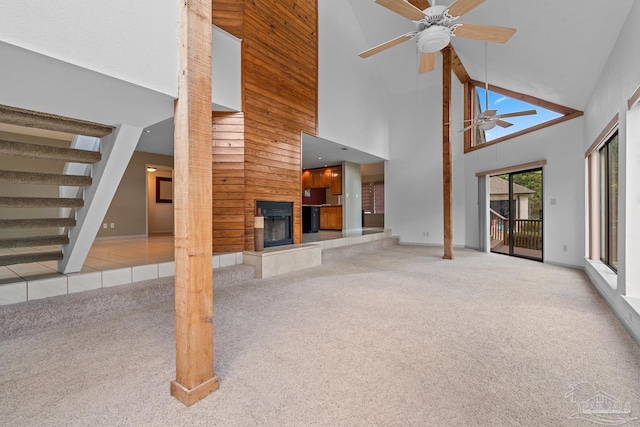 1567 Whisper Bay Blvd, Gulf Breeze, FL 32563 - unfurnished living room featuring a high ceiling, a tile fireplace, carpet floors, ceiling fan, and stairs