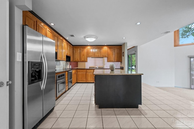 1567 Whisper Bay Blvd, Gulf Breeze, FL 32563 - kitchen featuring appliances with stainless steel finishes, light tile patterned floors, tasteful backsplash, a center island, and recessed lighting