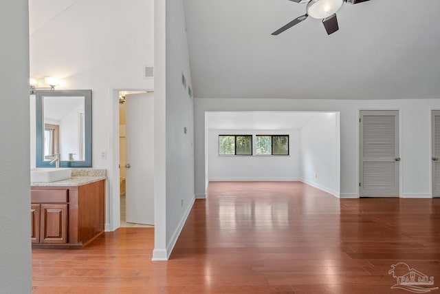 1567 Whisper Bay Blvd, Gulf Breeze, FL 32563 - unfurnished living room with ceiling fan, light wood finished floors, a sink, baseboards, and high vaulted ceiling