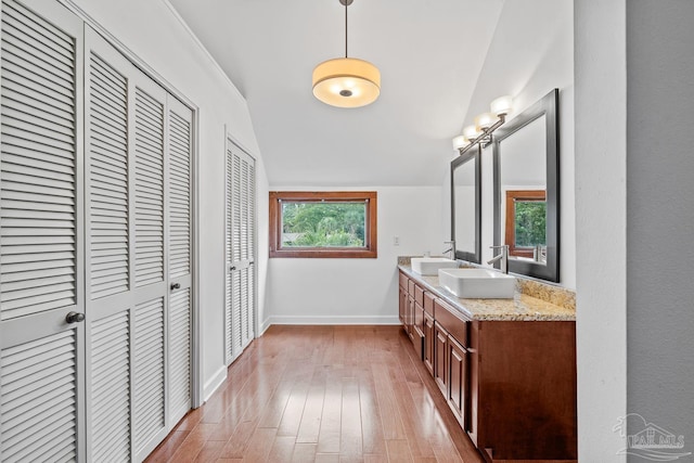 1567 Whisper Bay Blvd, Gulf Breeze, FL 32563 - bathroom featuring double vanity, a closet, hardwood / wood-style flooring, vaulted ceiling, and baseboards
