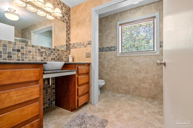 1567 Whisper Bay Blvd, Gulf Breeze, FL 32563 - bathroom with vanity, toilet, tile walls, a tile shower, and tile patterned floors