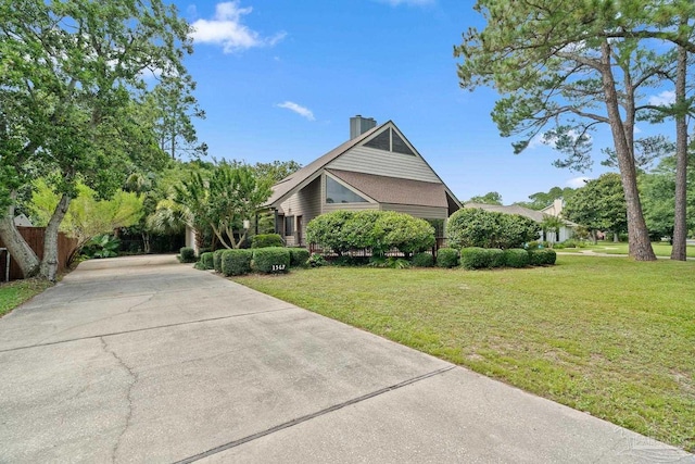 1567 Whisper Bay Blvd, Gulf Breeze, FL 32563 - view of front of house with driveway, a front lawn, and a chimney