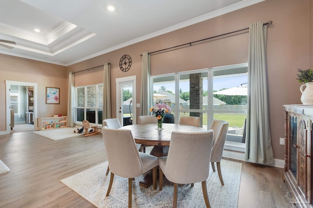dining room with plenty of natural light, light wood-style floors, crown molding, and baseboards