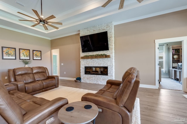 living room featuring a ceiling fan, visible vents, crown molding, wood finished floors, and a raised ceiling