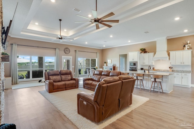 living area featuring crown molding, a ceiling fan, a wealth of natural light, and light wood finished floors