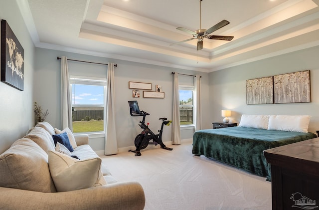 bedroom featuring a ceiling fan, a raised ceiling, baseboards, ornamental molding, and light carpet