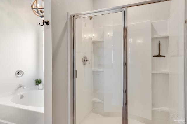 bathroom featuring a bath and a shower stall