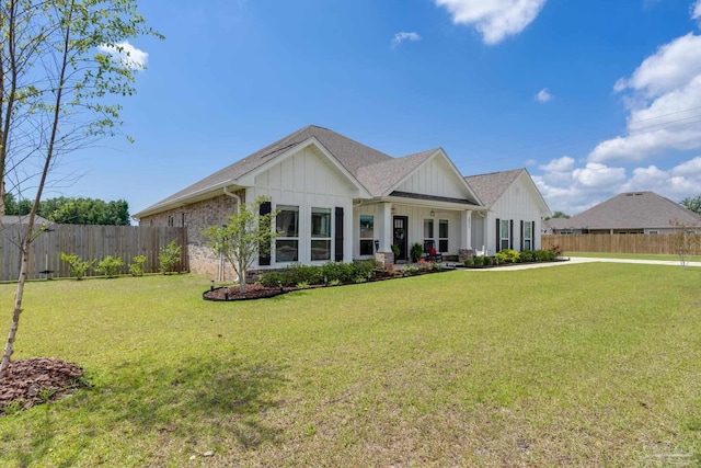 view of front of property featuring fence, board and batten siding, and a front yard