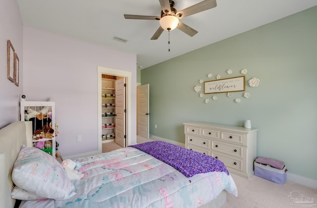 bedroom featuring visible vents, baseboards, ceiling fan, light colored carpet, and a spacious closet