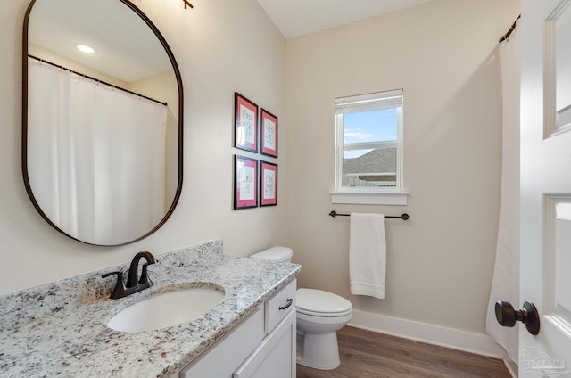 bathroom featuring vanity, baseboards, toilet, and wood finished floors
