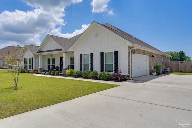 view of front facade with a garage, fence, a front yard, board and batten siding, and driveway