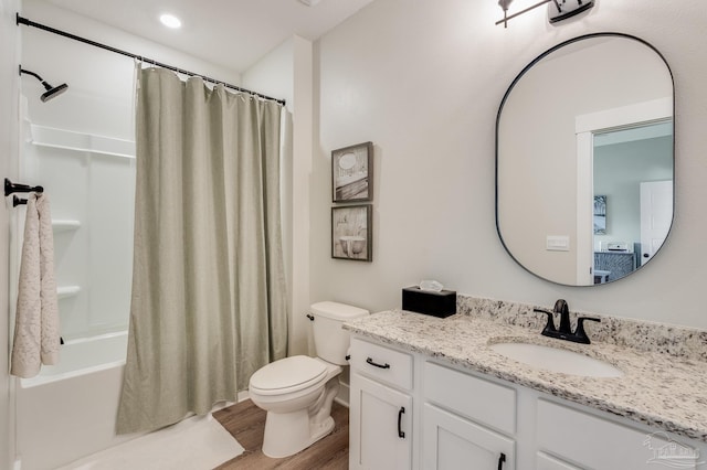 bathroom with vanity, toilet, wood finished floors, and shower / tub combo