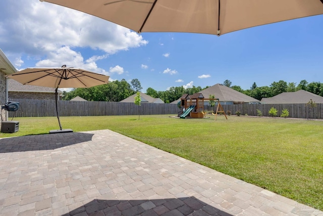 view of patio featuring a playground and a fenced backyard